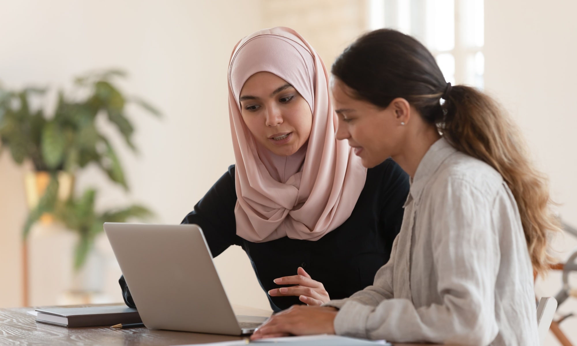 2 women learning on a laptop together